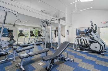 A gym with a variety of equipment including a leg press machine.